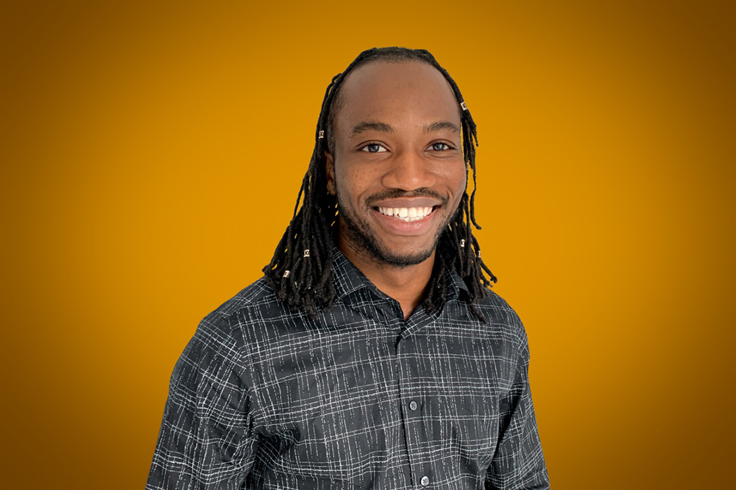 Heroic Headshot on orange background of business casual man taking remote virtual headshot.