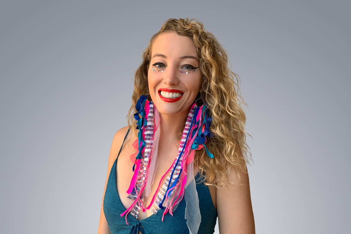 Heroic Headshot on grey background of woman in colorful clothes taking remote virtual headshot.