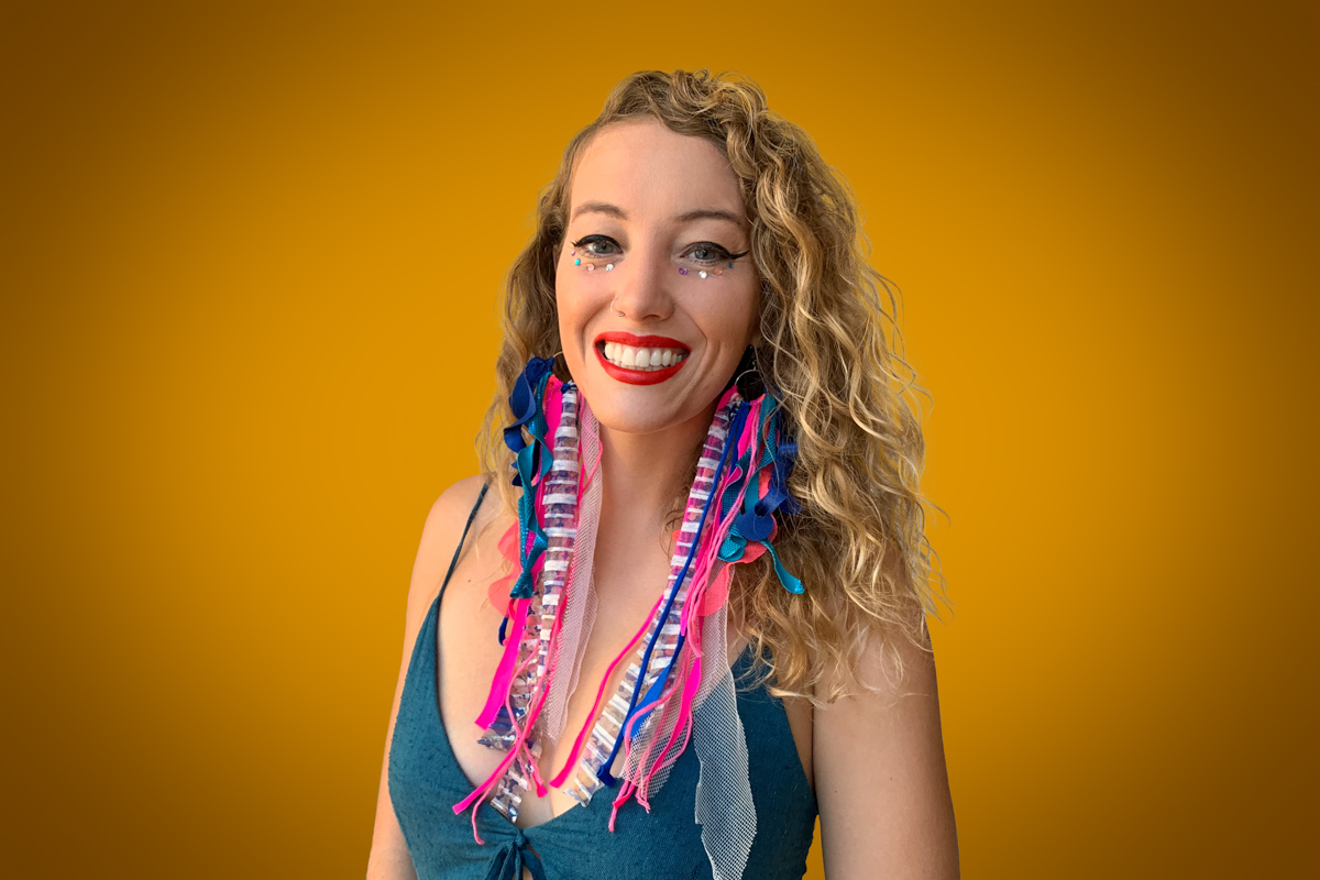 Heroic Headshot on orange background of woman in colorful clothes taking remote virtual headshot.