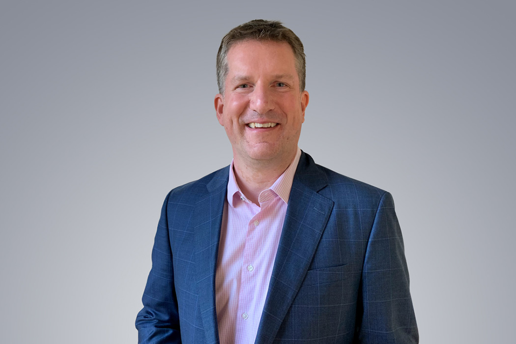 Heroic Headshot on grey background of business man in suit taking remote virtual headshot.