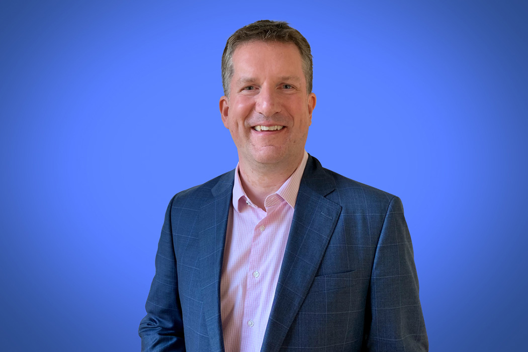 Heroic Headshot on blue background of business man in suit taking remote virtual headshot