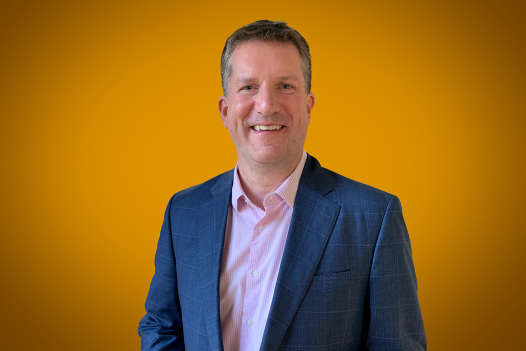 Heroic Headshot on orange background of business man in suit taking remote virtual headshot