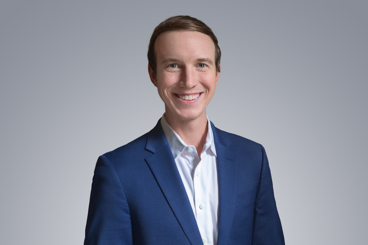 Heroic Headshot on grey background of business man in suit taking remote virtual headshot.