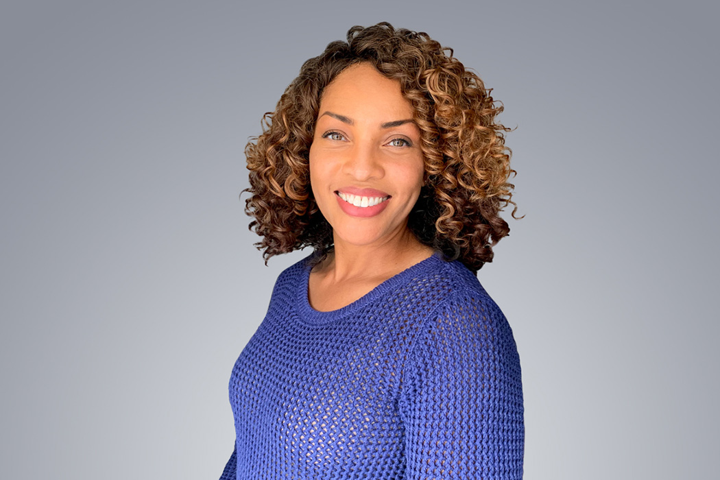 Heroic Headshot on grey background of business casual woman taking remote virtual headshot.