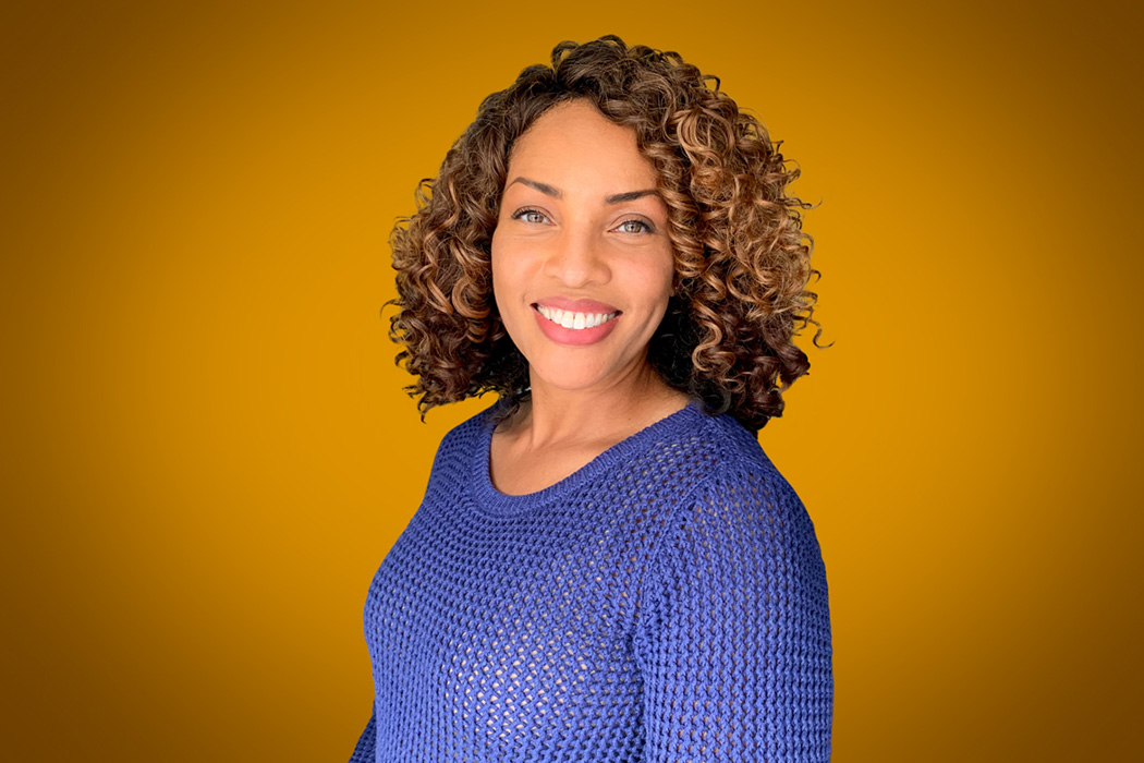 Heroic Headshot on orange background of business casual woman taking remote virtual headshot.