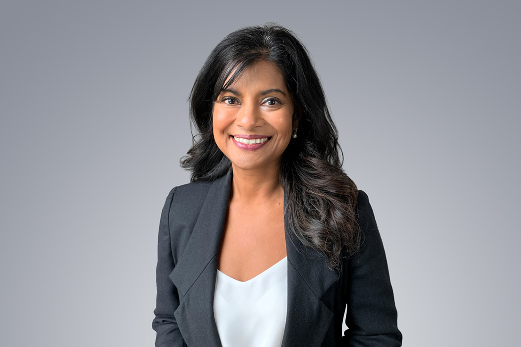 Heroic Headshot on grey background of business woman in suit jacket taking remote virtual headshot.